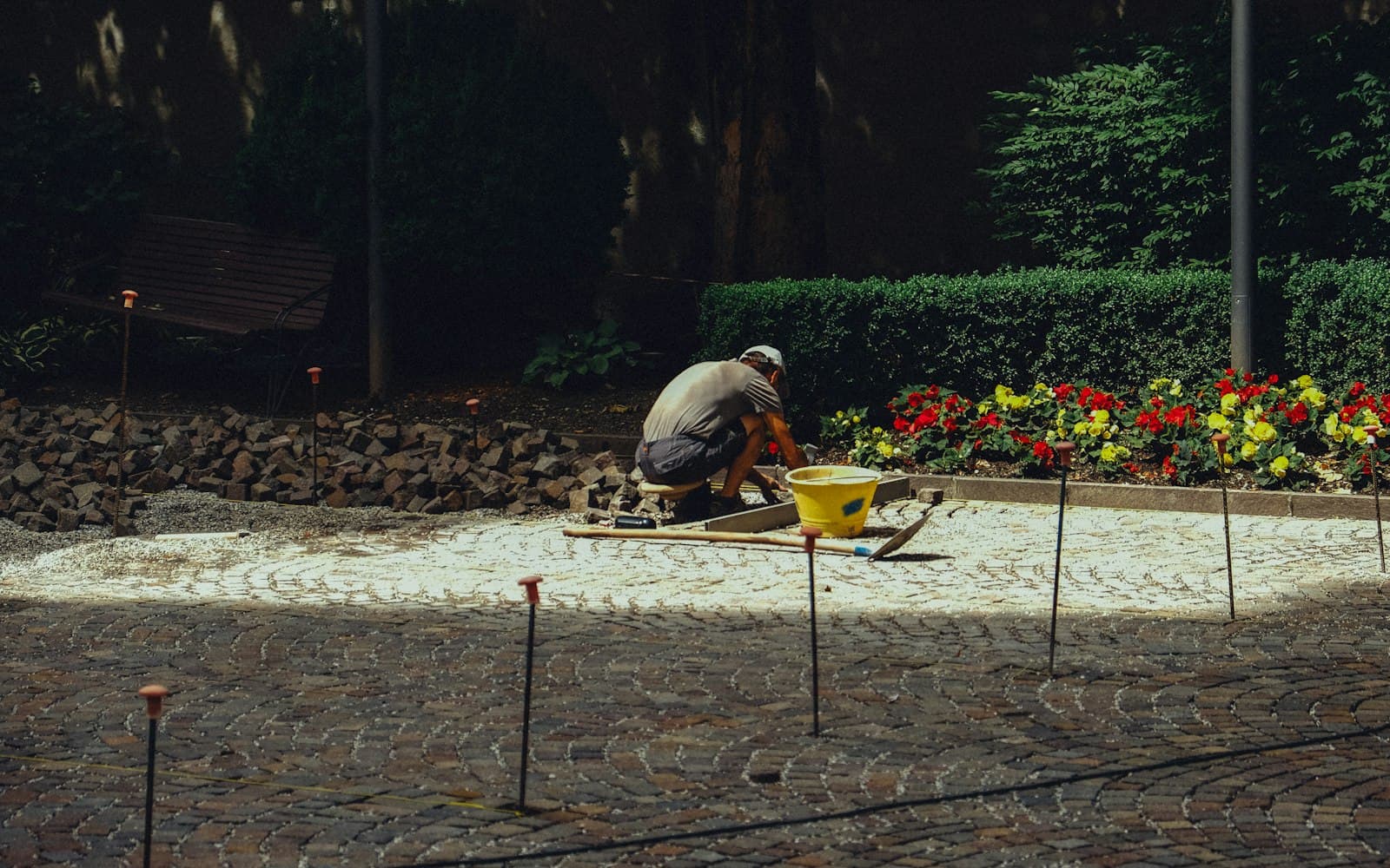 Trädgårdsarbetare lägger sten i rabatt