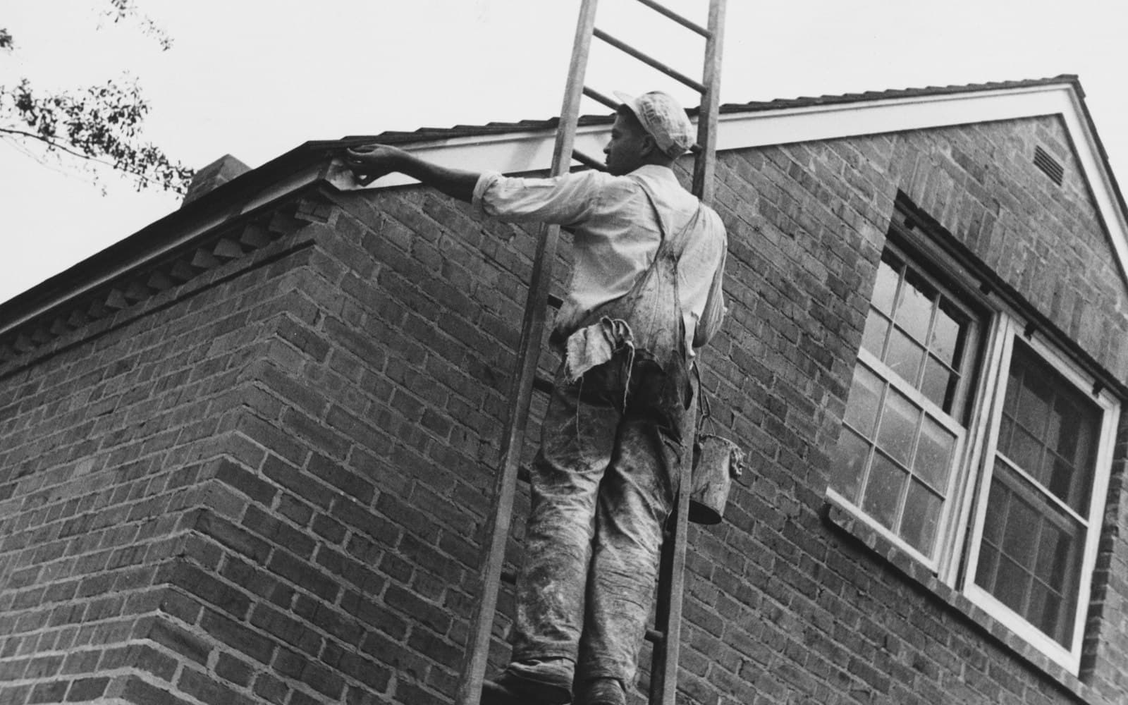 Hantverkare målar fasad på tegelbyggnad